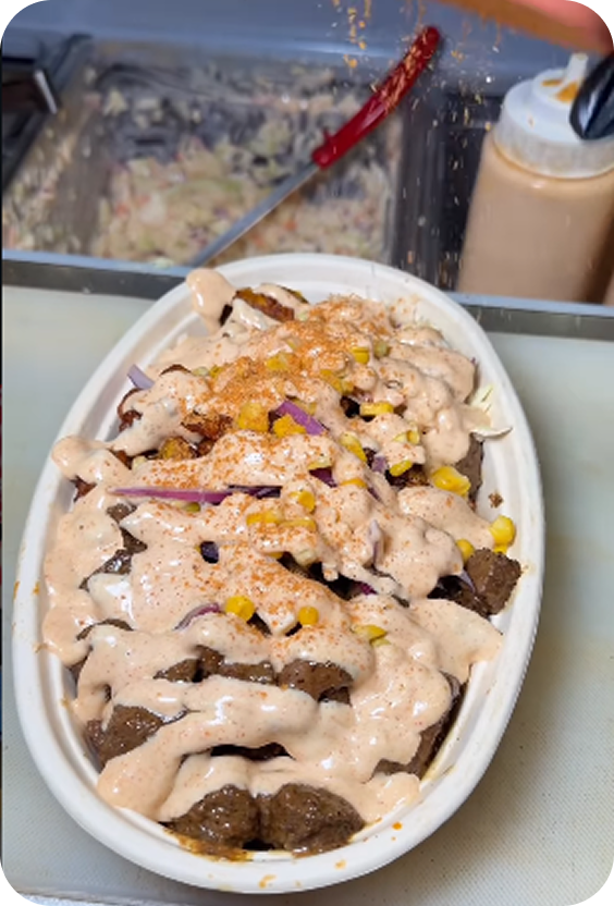 A finished Jollof Bowl topped with sauce and onions